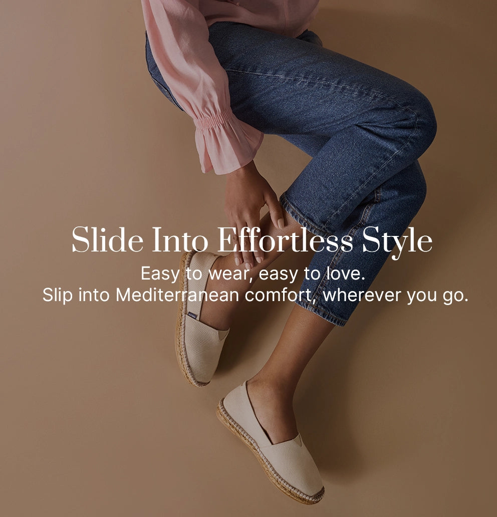 Woman wearing beige cream slip-on espadrilles with natural jute soles, styled with cropped jeans and a pink blouse, showcasing Viscata’s lightweight Mediterranean shoes designed for effortless comfort and everyday style.