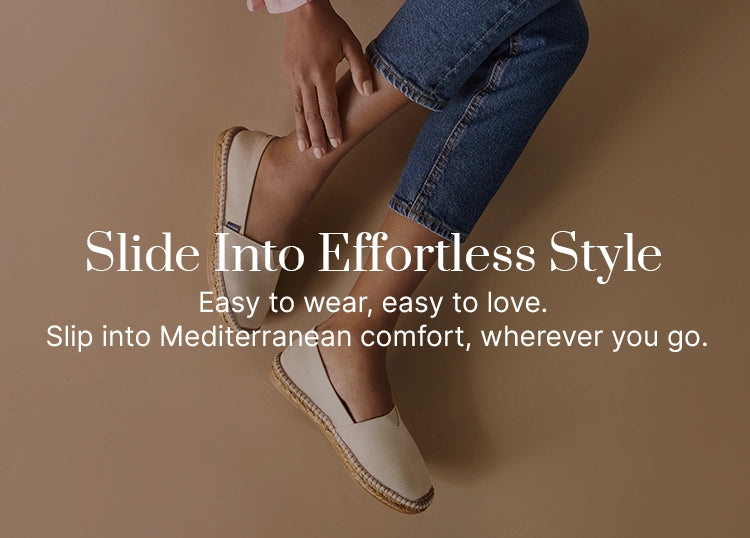 Woman wearing beige cream slip-on flat espadrilles with natural jute soles, styled with cropped jeans and a pink blouse, showcasing Viscata’s lightweight Mediterranean shoes designed for effortless comfort and everyday style.