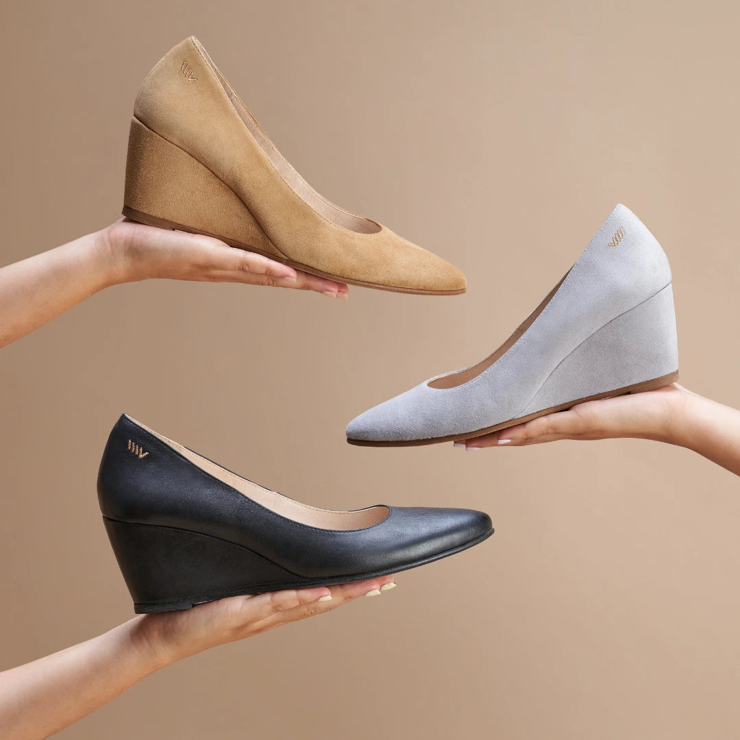Hands displaying black leather, ash grey suede and camel suede Verona medium wedge shoes