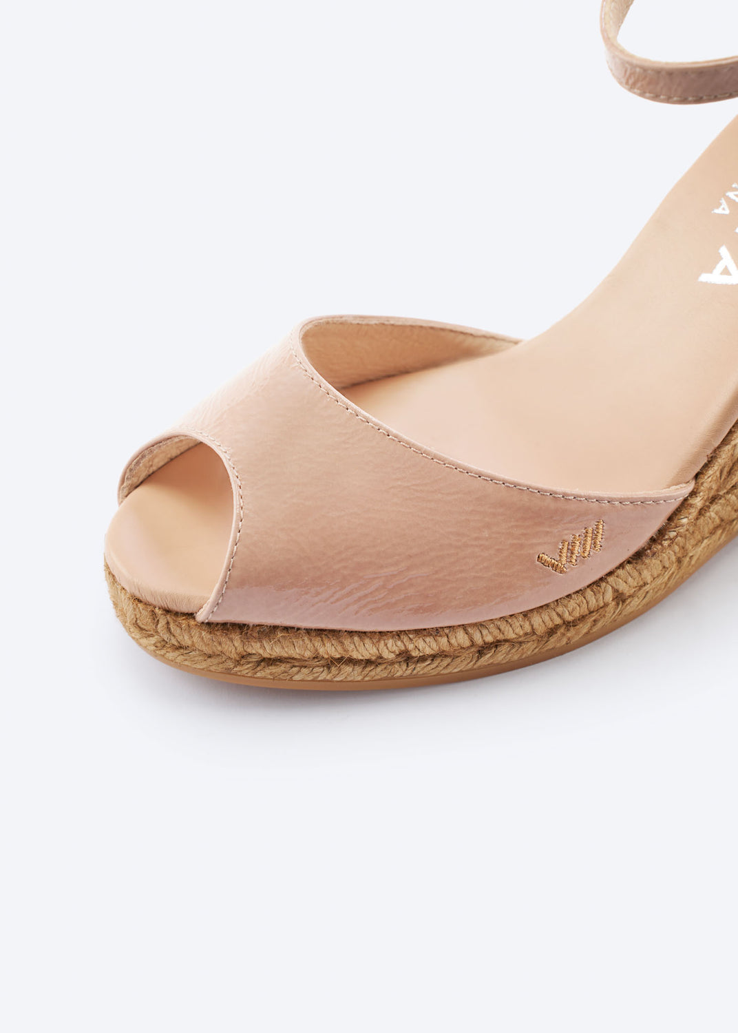 Close-up of blush pink leather wedge espadrille sandal with an open toe and natural braided jute sole, handcrafted in Spain