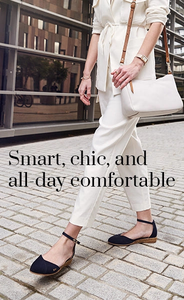 Viscata woman in white office 
tailored suit walking outdoors, styled with navy ankle-strap flat espadrilles. Smart, chic, and all-day comfortable footwear for a modern lifestyle