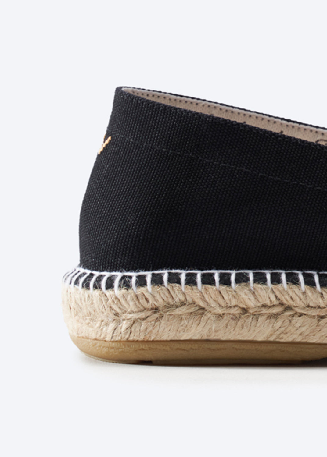 Close-up of a black canvas espadrille heel with jute sole.