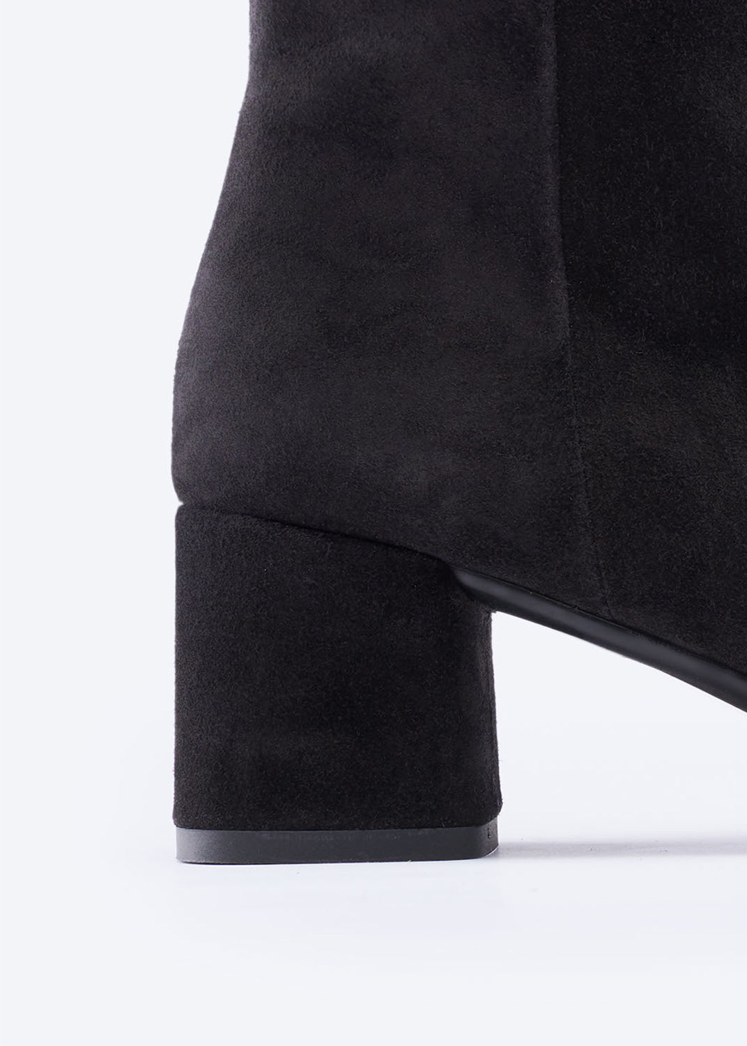 Black suede knee-high boot on a white background