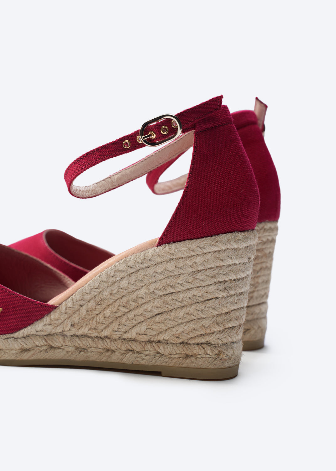 Red wedge sandals with jute sole on a white background