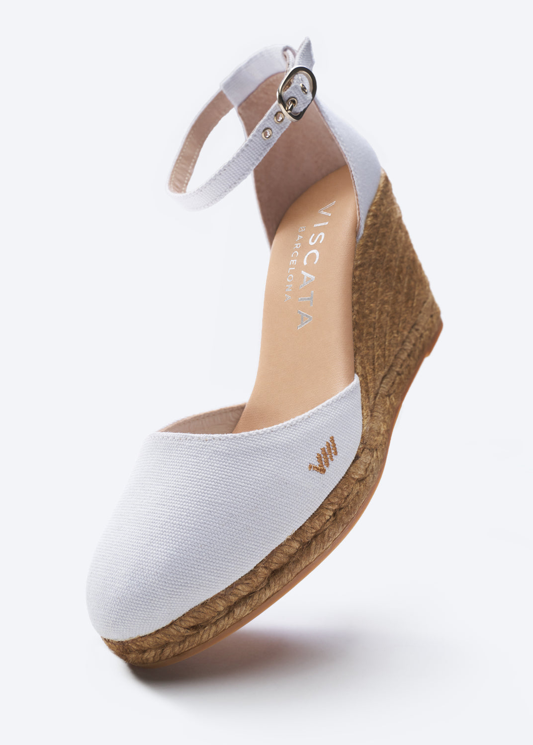 White wedge sandal with brown sole on a white background