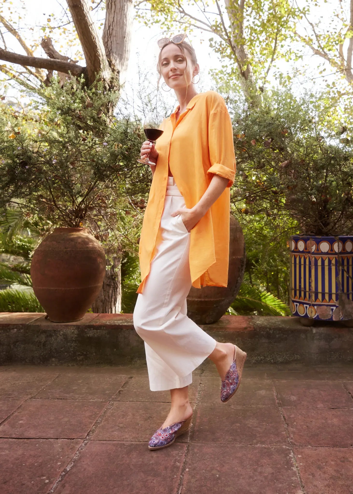 Woman with an orange shirt, white pants and cashermere canvas mule espadrilles outfit