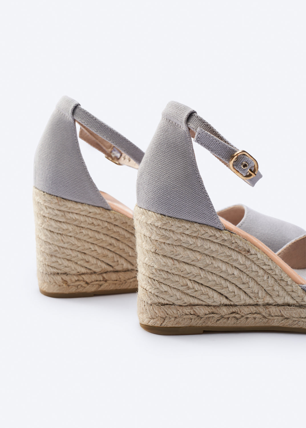 Pair of gray wedge sandals with jute sole on a white background