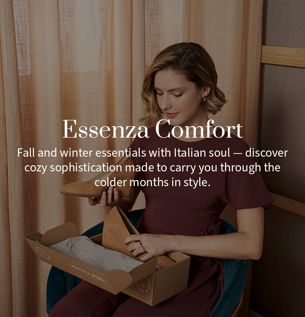 Promotional banner for the Essenza Collection. A woman in a burgundy dress sits opening a Viscata shoebox containing suede shoes. Text reads: “Essenza Comfort – Fall and winter essentials with Italian soul — discover cozy sophistication made to carry you through the colder months in style.”