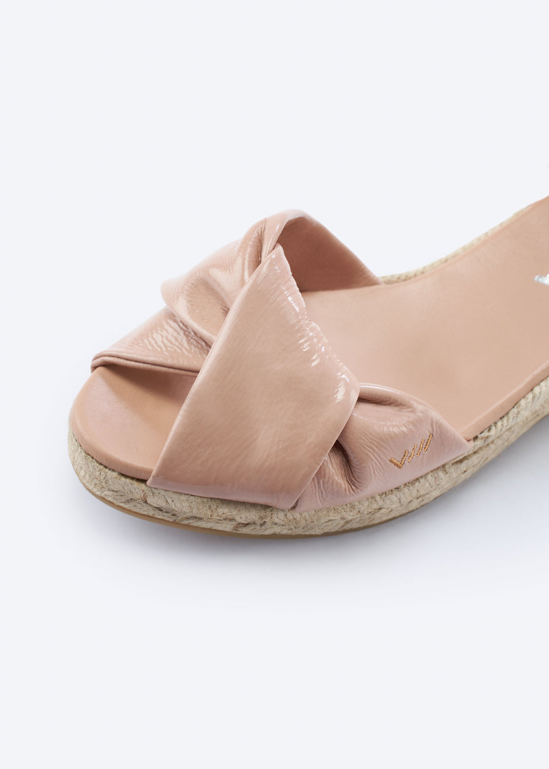 Close-up of pink leather espadrille sandal with knotted front detail and braided jute sole.