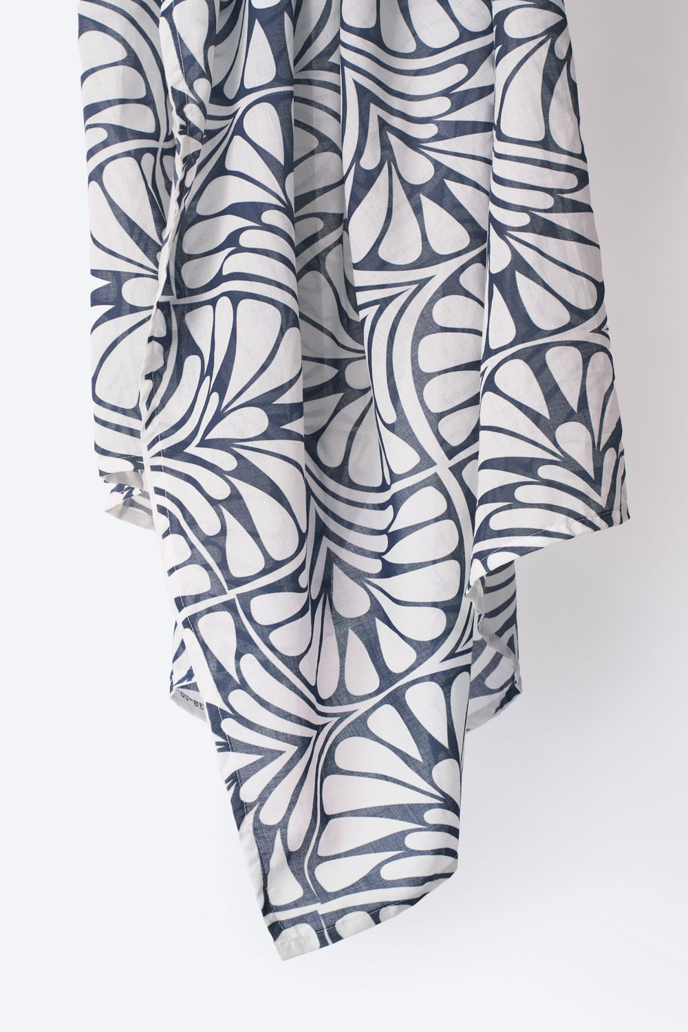 Detail of the Blue Palms foulard draped on display, featuring a bold navy and white palm-inspired geometric print on soft, lightweight fabric
