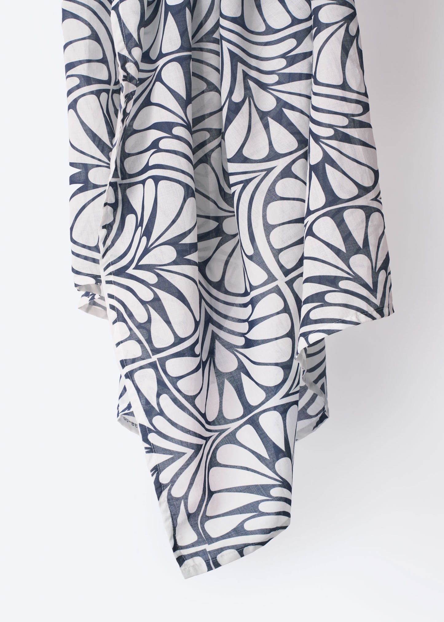 Detail of the Blue Palms foulard draped on display, featuring a bold navy and white palm-inspired geometric print on soft, lightweight fabric