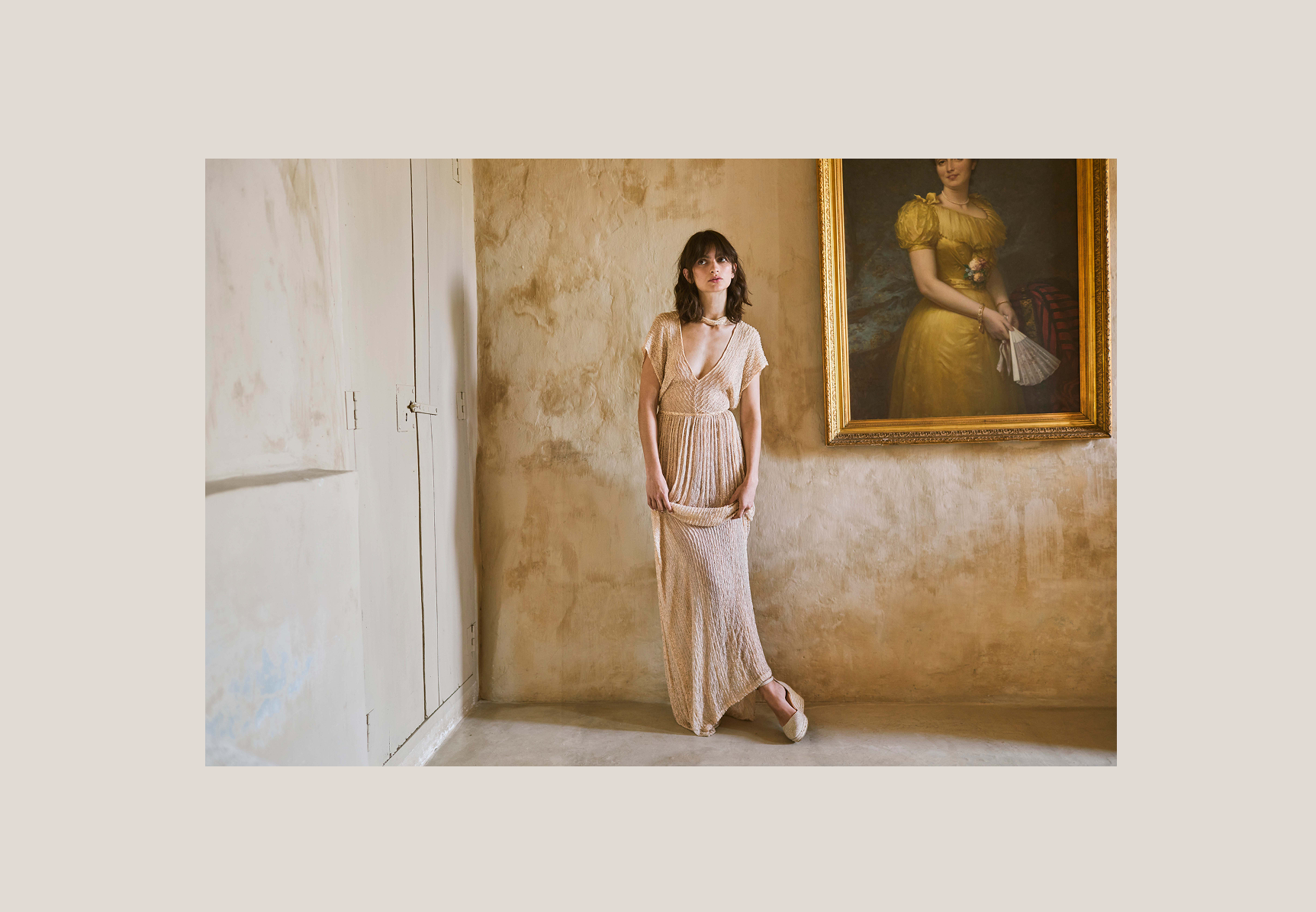 Woman wearing ivory beige espadrille flats and a flowing textured dress in an elegant Mediterranean interior.