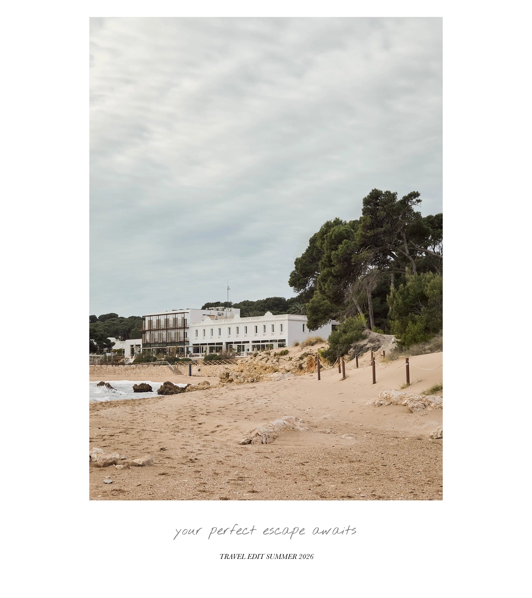 A travel poster or art print featuring a scenic photograph of a white seaside building on a sandy beach under a cloudy sky, with the text 'your perfect escape awaits' and 'TRAVEL EDITION SUMMER 2026' printed below.