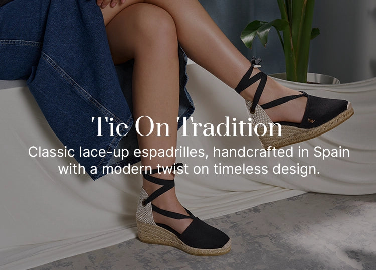 Woman wearing black lace-up medium wedge espadrilles by Viscata, handcrafted in Spain with traditional jute soles, styled with a denim skirt indoors