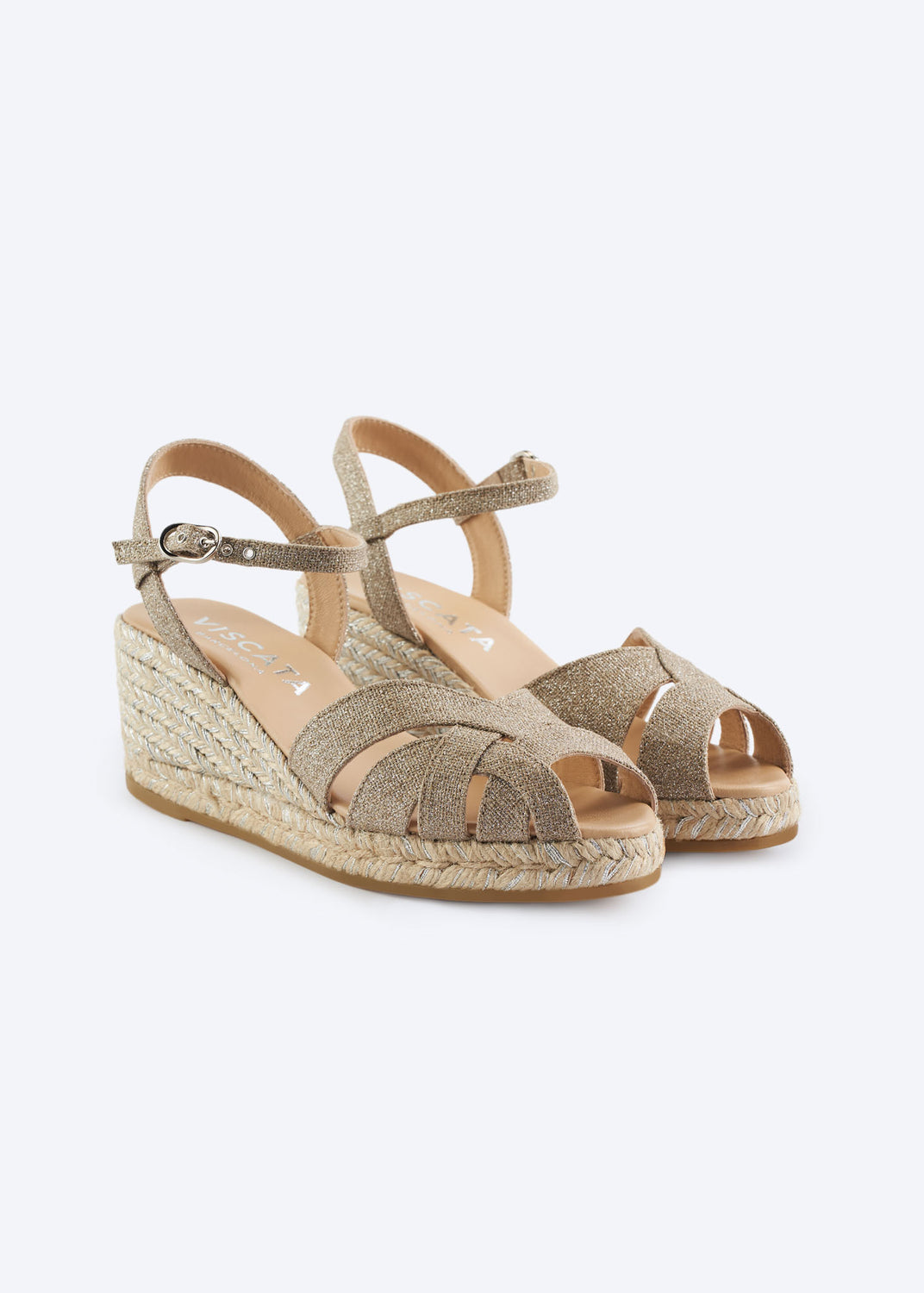 Silver metallic espadrille wedge sandals with crossover straps and braided jute sole on a clean background.