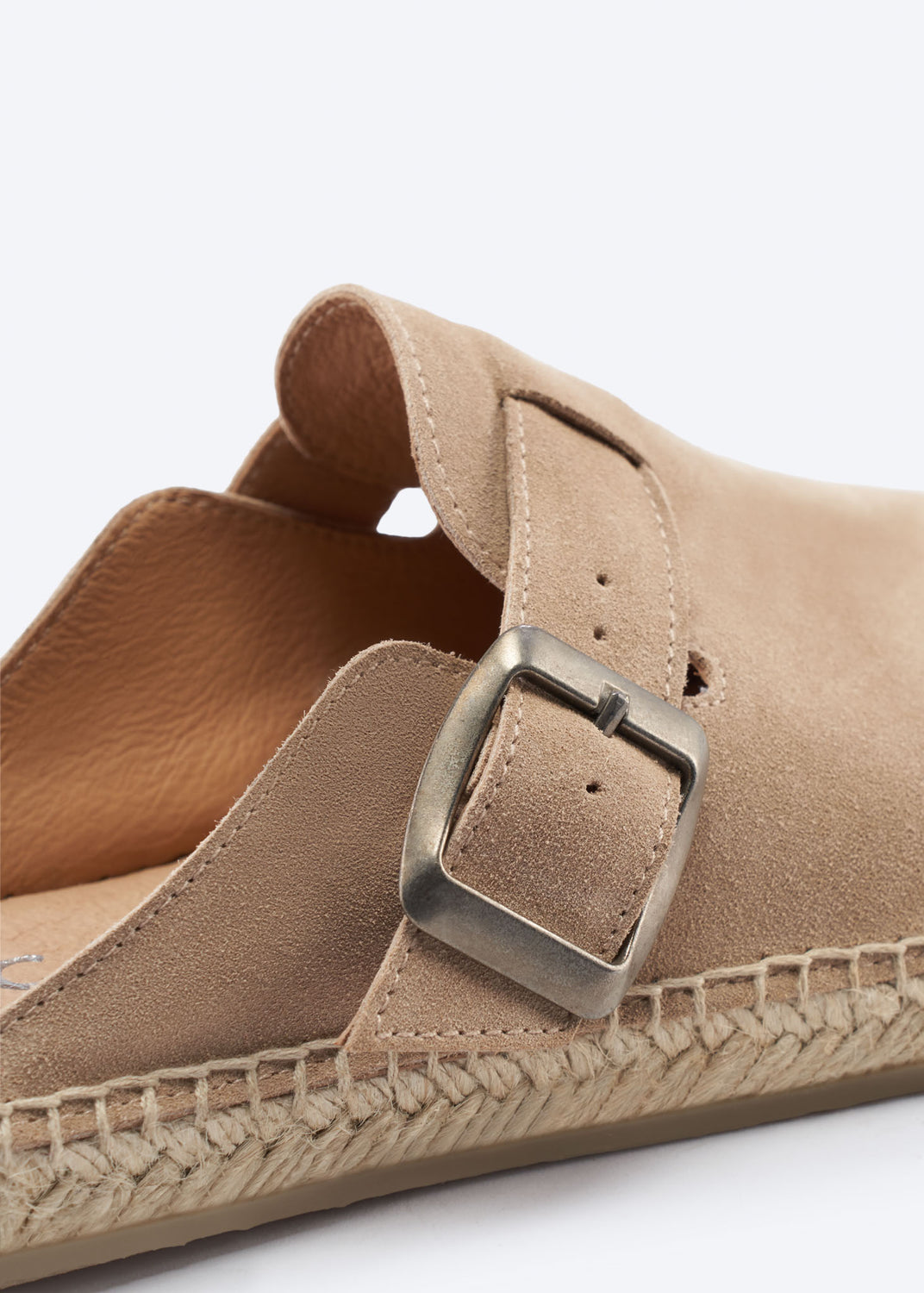 Close-up of a camel suede espadrille clog buckle and jute sole.