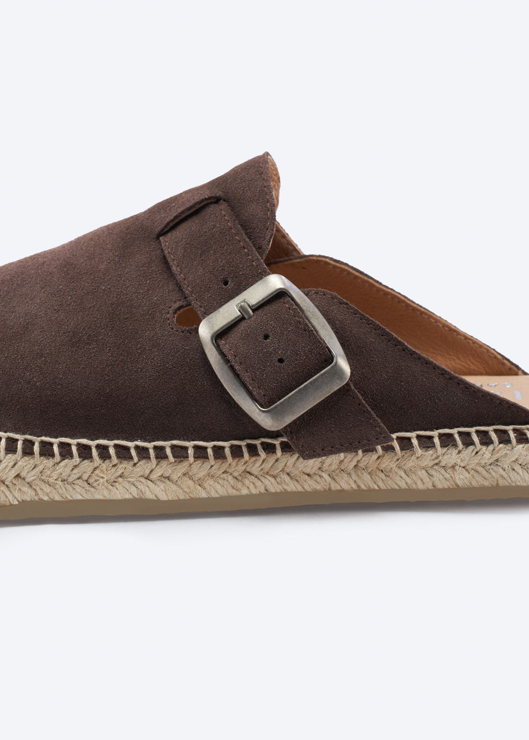 Close-up of a brown suede espadrille clog buckle and jute sole.