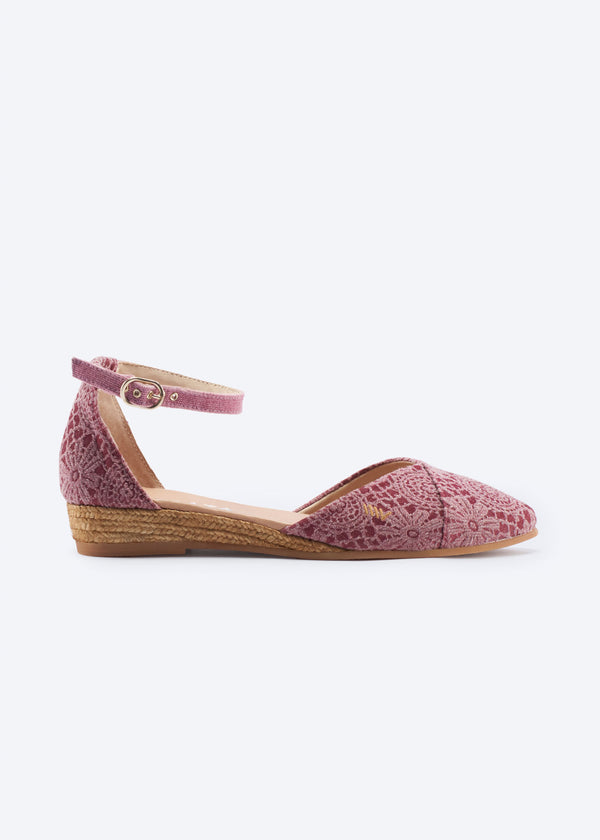 Side view of pink crochet espadrille flat with ankle strap and low jute wedge.