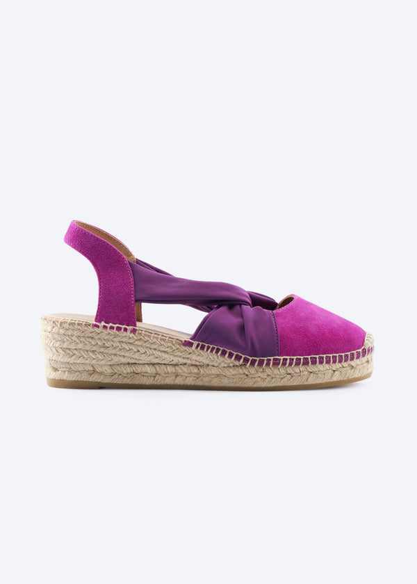 Fuchsia suede slingback espadrille wedge with purple knot strap, side view.