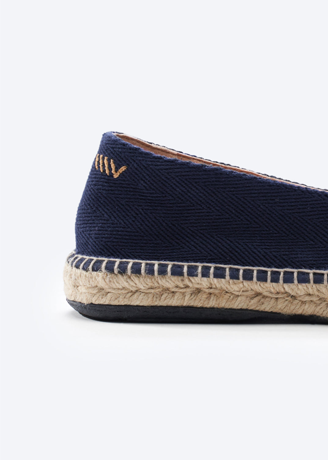 Navy blue espadrille shoe with jute sole on a white background