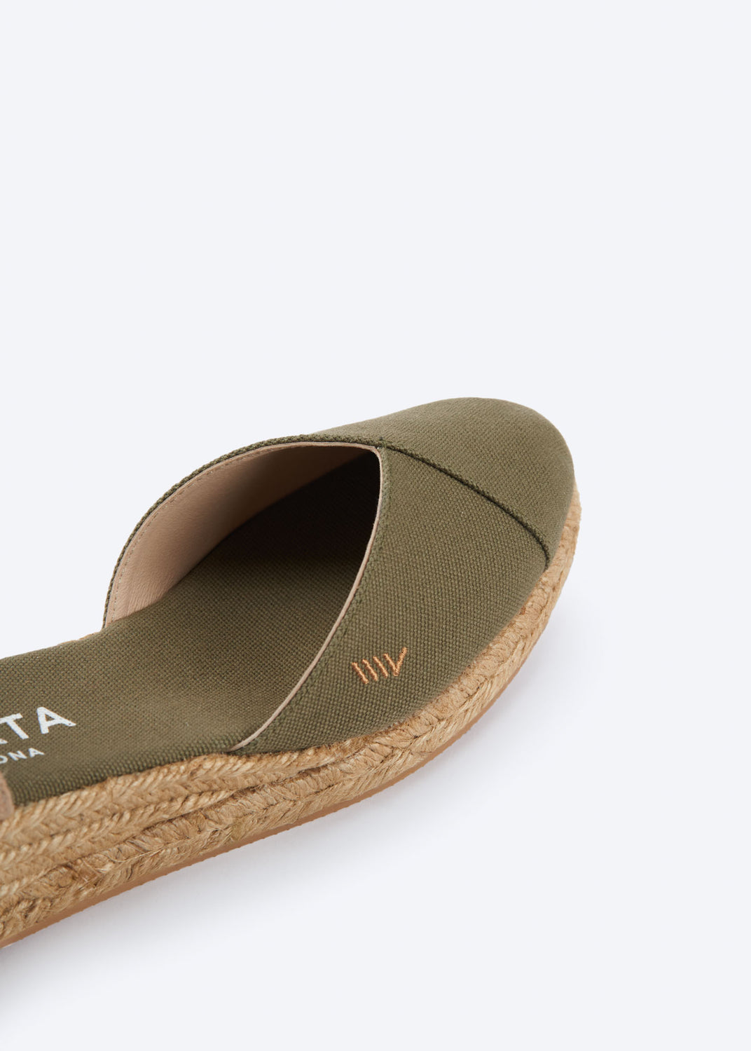 Close-up of olive green espadrille sandal with crossed vamp and natural braided jute sole, handcrafted in Spain