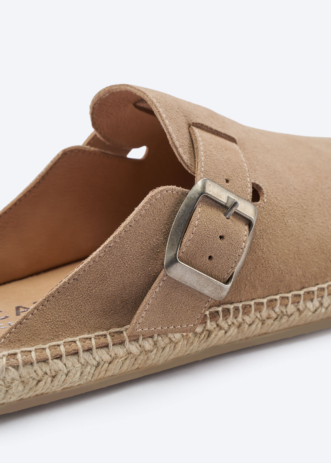 Close-up of a camel suede espadrille mule buckle and jute sole.