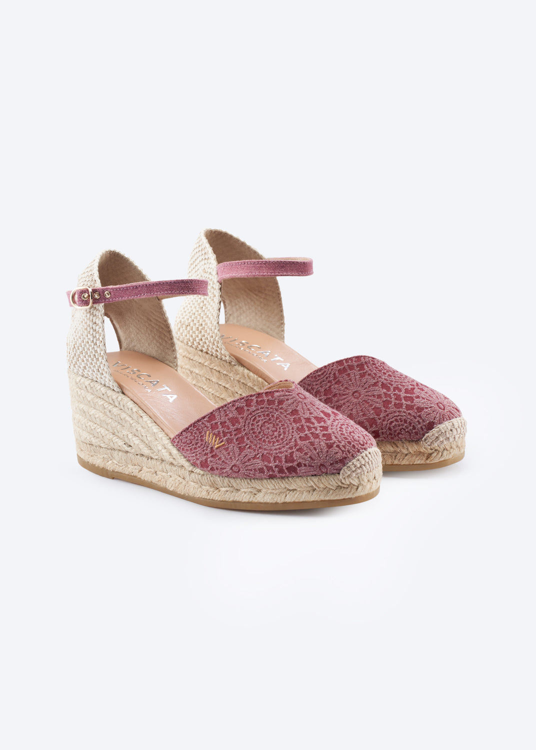 Pink crochet espadrille wedges with ankle strap and woven jute heel on a clean neutral background.