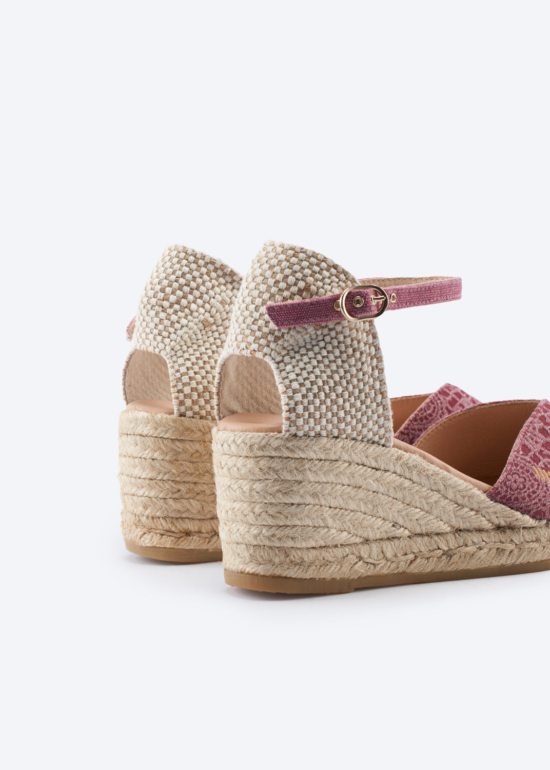 Close-up of espadrille wedge heel with woven texture and pink ankle strap, highlighting jute sole detail.