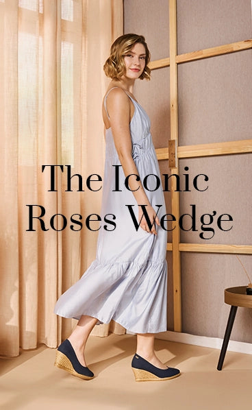 Woman in a light blue maxi dress wearing Viscata’s iconic Roses wedge espadrilles in navy canvas with natural jute medium heels