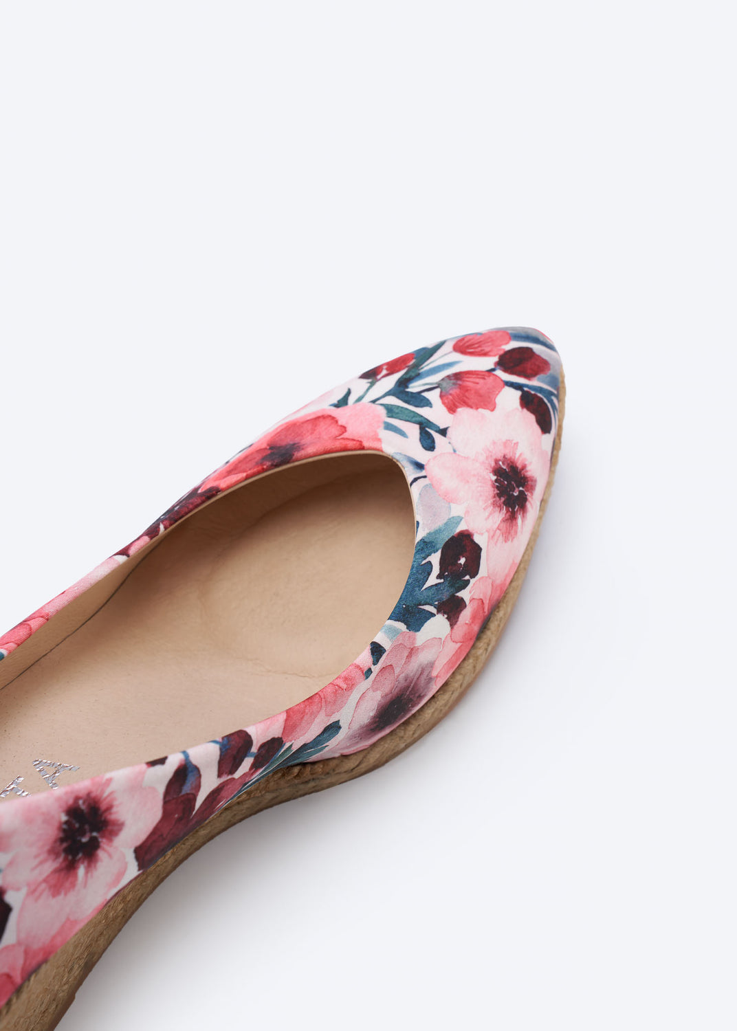 Close-up of a floral print wedge espadrille pump with a pointed toe, handcrafted in Spain