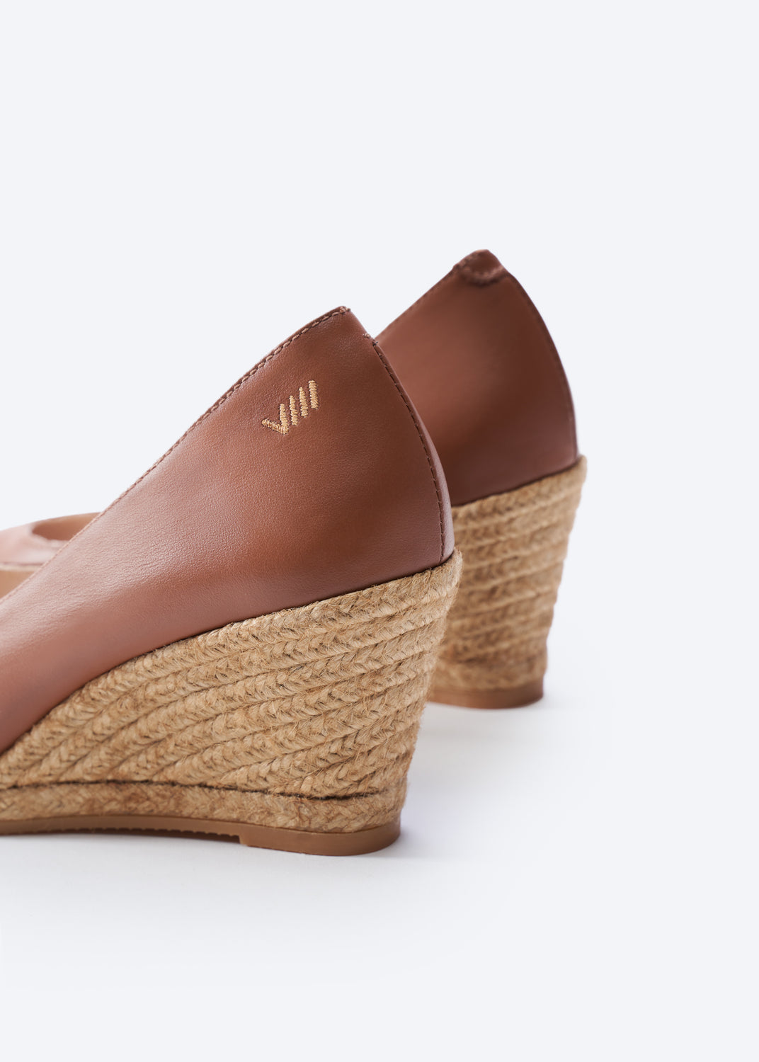 Close-up of brown leather espadrille wedge heel with jute wrap.