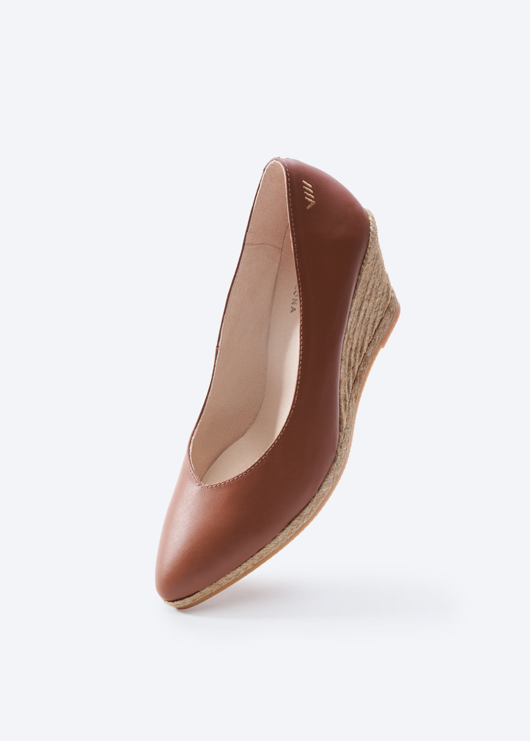 Brown leather wedge espadrille pump with jute heel, three-quarter view.