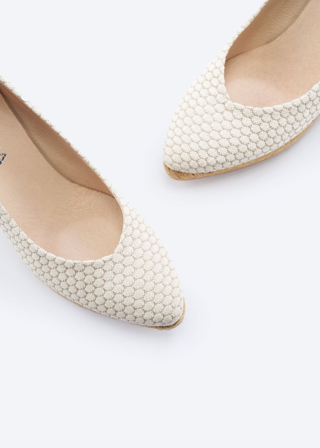 Close-up of white mesh wedge espadrille pumps with a pointed toe silhouette, handcrafted in Spain