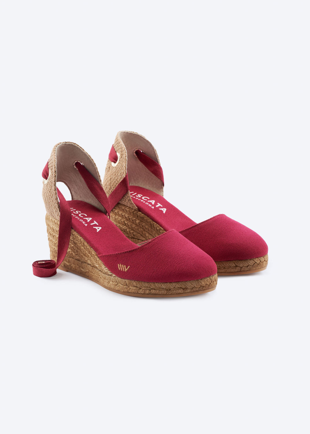 Cherry red wedge espadrille sandals with wraparound ankle ties, a closed toe, and natural braided jute wedge, handcrafted in Spain