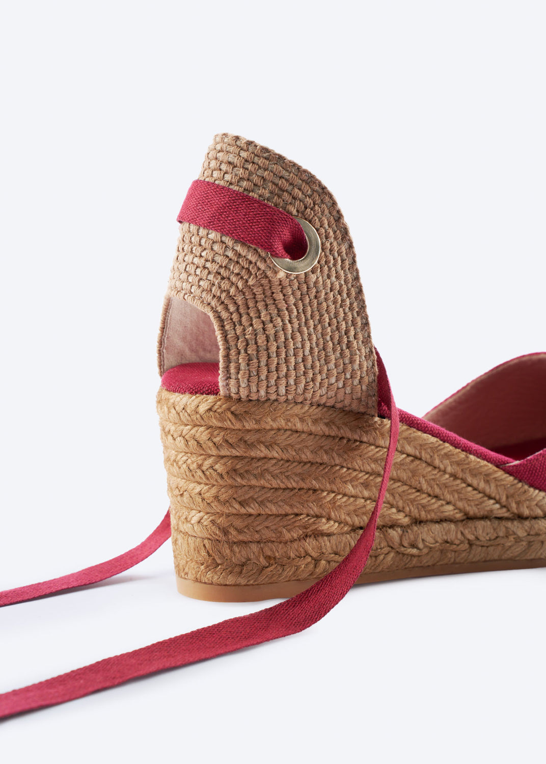 Close-up of cherry red espadrille wedge with wraparound ankle ties and a natural braided jute heel, handcrafted in Spain