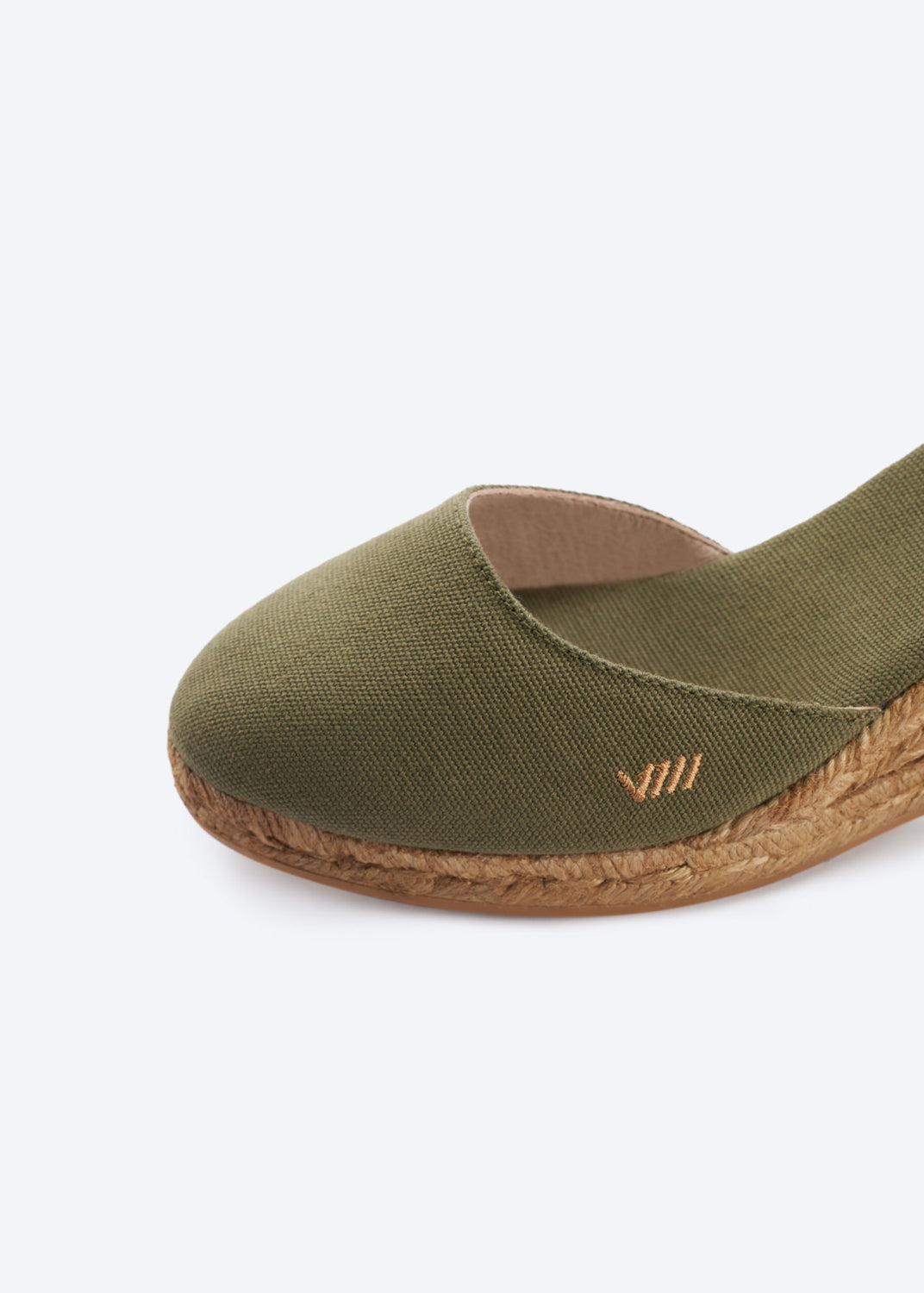Close-up of olive green espadrille wedge sandal with a closed toe and natural braided jute sole, handcrafted in Spain