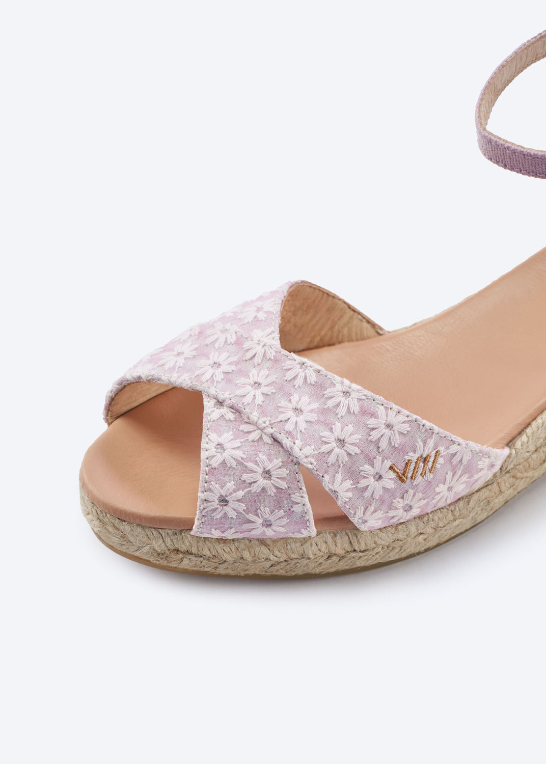 Close-up of pale pink floral wedge espadrille sandal with crossover front straps and a natural braided jute sole, handcrafted in Spain