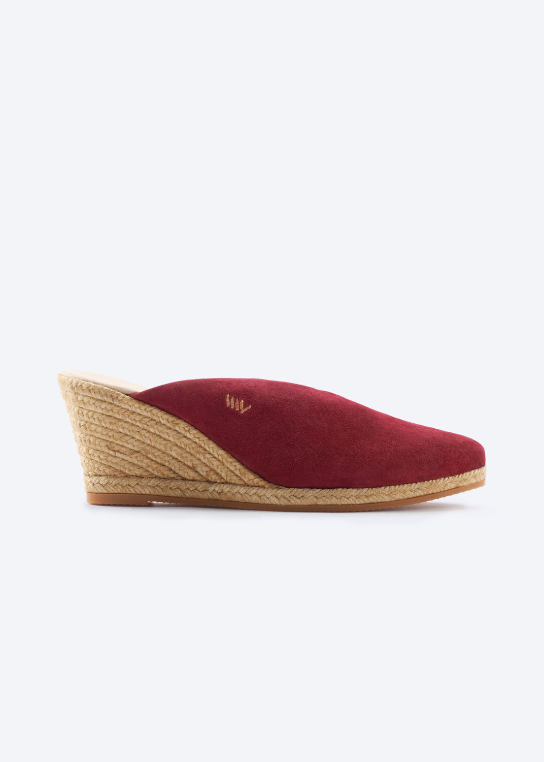 Side view of burgundy suede wedge espadrille mules with a closed toe and natural braided jute wedge, handcrafted in Spain